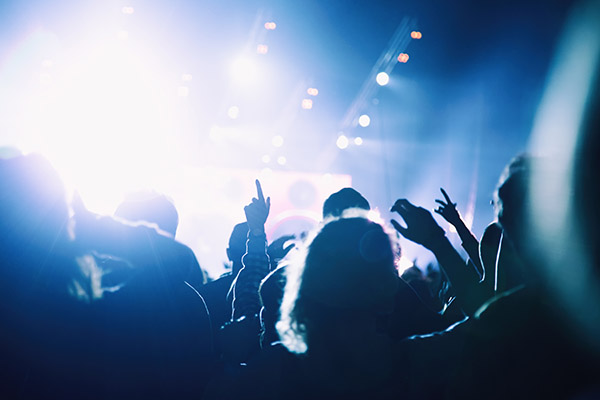 crowd of people facing forwards in the dark listening to a concert crowd of people facing forwards in the dark listening to a concert